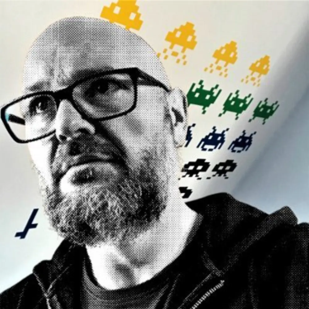 Christian A. Dumais in his office with Space Invaders on his wall.